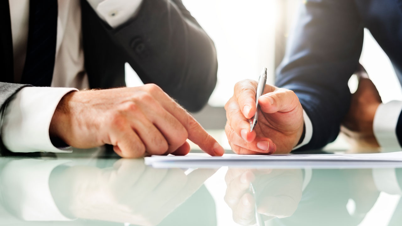 Dois empresários conferindo uma lista de aceleradora de vendas para contratar o melhor parceiro