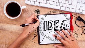 Pessoa escrevendo ideias e um caderno