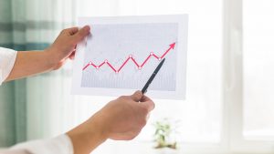 mãos de um empresário analisando o crescimento dos dados e calculando a taxa de conversão