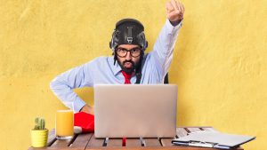 homem com capacete de aviador sentado na frente do notebook e pronto para embarcar na jornada do cliente