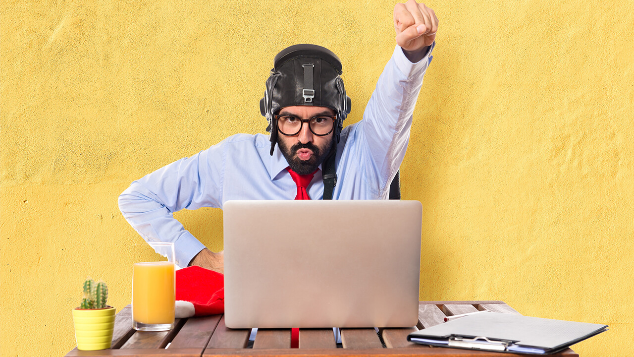 homem com capacete de aviador sentado na frente do notebook e pronto para embarcar na jornada do cliente