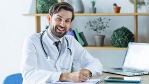 médico feliz por descobrir o que é lead e conferindo os agendamentos em uma prancheta