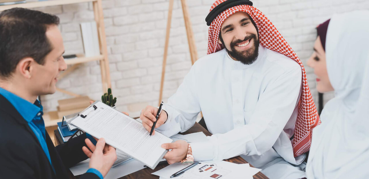 Vendedor usando terno, fechando uma venda usando técnicas de rapport, sem espelhar as roupas dos clientes que usam vestimentas árabes.