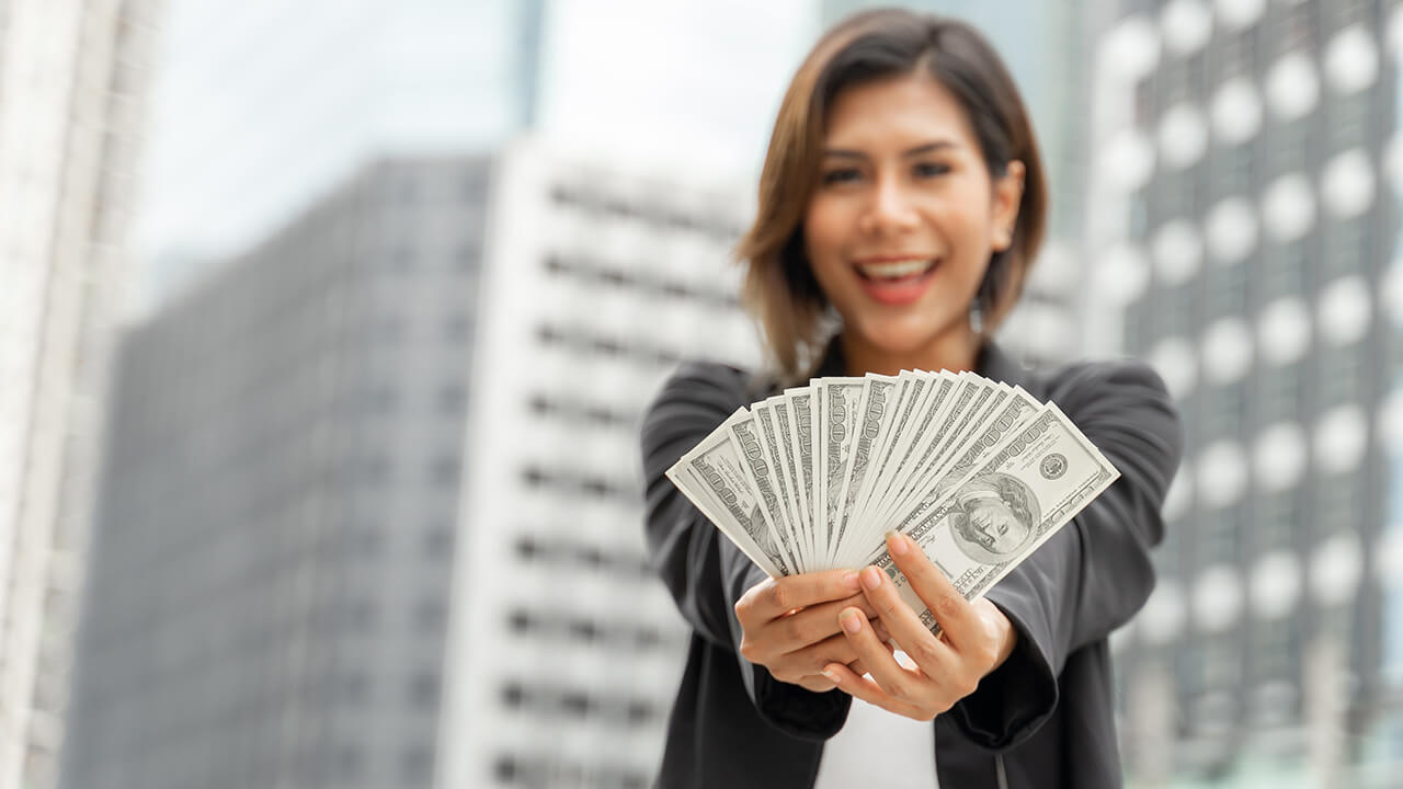 Executiva jovem bem sucedida com dinheiro na mão, fruto de venda consultiva