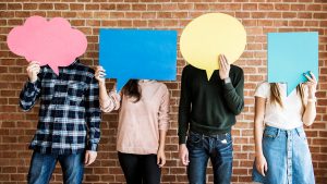 grupo de pessoas desconhecidas segurando balões na frente do rosto que representam o público-alvo sem segmentação