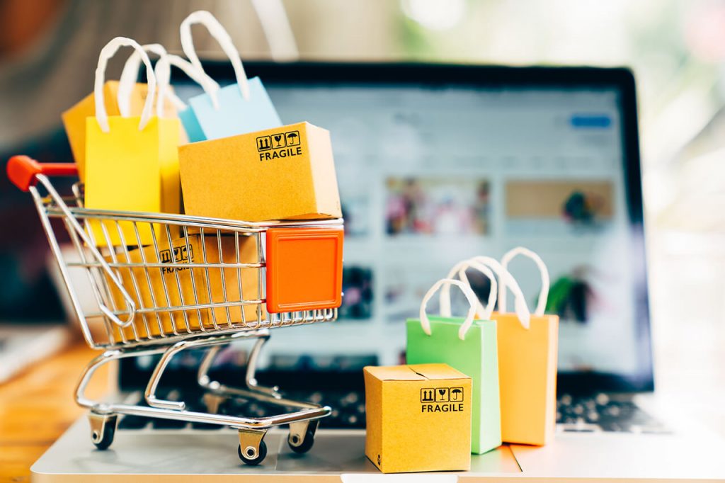 Carrinho de compras e notebook representando a jornada de compra